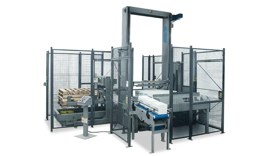 A low-level palletizer with a tall elevator frame, mesh guarding, an infeed conveyor, and a pallet stack.