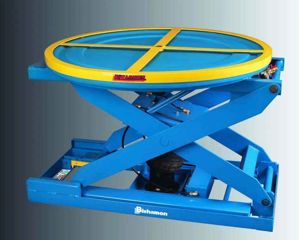 A blue scissor-frame pallet positioner with an air spring at its base and a yellow rotator ring on top.