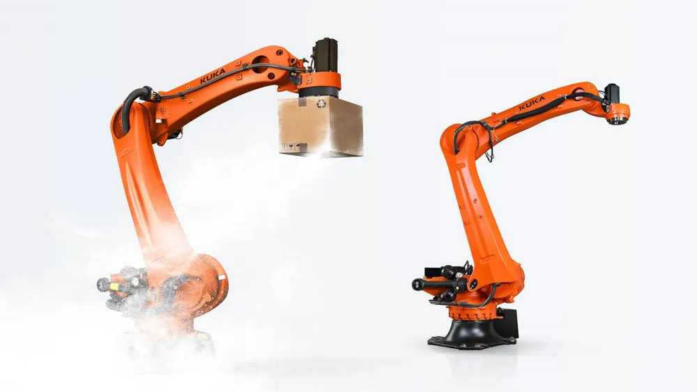 Two orange KUKA KR QUANTEC PA palletizing robots, one holding a cardboard case with a gripper.