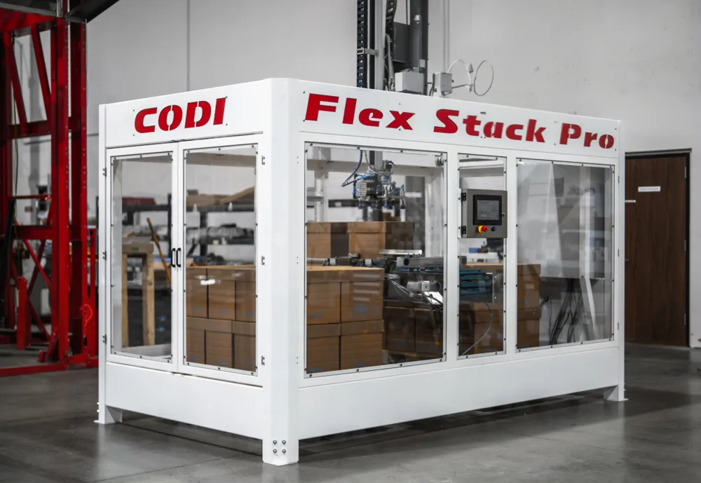 A white enclosed gantry palletizer with clear panels and a stacked pallet of boxes inside.